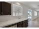 Featuring a kitchen sink with tile countertops with an adjacent patio door that fills the room with light at 829 Dancing Vines Ave, Las Vegas, NV 89183