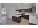 Well-lit kitchen with stainless steel appliances, dark wood cabinets, and center island with white countertop at 829 Dancing Vines Ave, Las Vegas, NV 89183