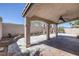 Large covered patio with stone pillars, offering a shady retreat and an open view of the backyard at 829 Dancing Vines Ave, Las Vegas, NV 89183