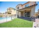 Relaxing backyard with artificial grass and covered patio of a two-story home at 871 Aurelie Ridge St, Henderson, NV 89011