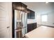 Modern kitchen features stainless steel refrigerator, dark cabinets, and quartz countertops at 871 Aurelie Ridge St, Henderson, NV 89011