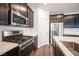 Close-up shot of stainless steel stove, dark cabinets, and quartz countertops in a well-lit kitchen at 871 Aurelie Ridge St, Henderson, NV 89011