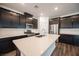 Modern kitchen features dark cabinets, stainless steel appliances, and a large quartz countertop island at 871 Aurelie Ridge St, Henderson, NV 89011