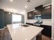 Close-up of a kitchen island with a stainless steel sink, dark cabinets, and quartz countertops at 871 Aurelie Ridge St, Henderson, NV 89011