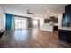 Open-concept living space with wood floors, modern ceiling fan, and sliding glass doors to the backyard at 871 Aurelie Ridge St, Henderson, NV 89011
