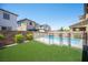 Backyard view of a pool with a safety fence and artificial grass in a newly constructed neighborhood at 871 Aurelie Ridge St, Henderson, NV 89011