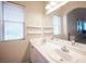 Bright bathroom featuring a double sink vanity, arched doorway, and natural light from a window at 9322 Straw Hays St # 103, Las Vegas, NV 89178