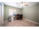Bright bedroom with light green walls, wood-look flooring, ceiling fan, and ample closet space at 9322 Straw Hays St # 103, Las Vegas, NV 89178