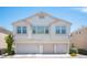Home featuring a three-car garage and stucco facade under a clear sky in a residential neighborhood at 9322 Straw Hays St # 103, Las Vegas, NV 89178