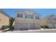 Inviting two-story townhome with a two-car garage, complemented by manicured landscaping at 9322 Straw Hays St # 103, Las Vegas, NV 89178