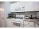 Close-up of a kitchen featuring white cabinets, stove, and modern appliances at 9322 Straw Hays St # 103, Las Vegas, NV 89178