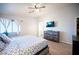 Main bedroom featuring a bed, wood-look floors, ceiling fan, natural light, and ensuite bathroom access at 9322 Straw Hays St # 103, Las Vegas, NV 89178