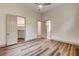 Bright bedroom with a ceiling fan, wood floors, and doorways to closets and bathrooms at 9921 Mirada Dr, Las Vegas, NV 89144