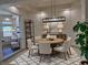 Bright dining room features modern light fixture, round table, and view of the upper floor at 9921 Mirada Dr, Las Vegas, NV 89144