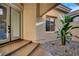 Contemporary entryway with a glass-paneled door, a large window, and natural rock landscaping at 9921 Mirada Dr, Las Vegas, NV 89144