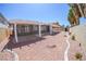 Backyard showcasing covered patio, gravel landscape, stone perimeter, and privacy wall at 1519 Deerford Cir, Las Vegas, NV 89110