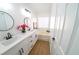 Bright bathroom featuring double sinks, framed mirrors, a soaking tub, and wood-look tile at 1519 Deerford Cir, Las Vegas, NV 89110