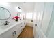 Bright bathroom featuring double sinks, framed mirrors, a soaking tub, and wood-look tile at 1519 Deerford Cir, Las Vegas, NV 89110