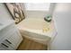 Bathroom with a soaking tub, white tile surround, and gold-toned hardware at 1519 Deerford Cir, Las Vegas, NV 89110