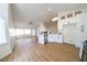Bright, open kitchen and living area featuring wood-look floors and modern white cabinets at 1519 Deerford Cir, Las Vegas, NV 89110