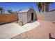 Backyard featuring a storage shed, surrounded by a brick wall and gravel landscape at 1519 Deerford Cir, Las Vegas, NV 89110