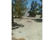 View of gravel backyard with scattered brush and mature trees enhancing the surrounding landscape at 1611 Red Rock Dr, Pahrump, NV 89048