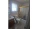 Well-lit bathroom with a window, tub-shower combo with glass doors, and a single sink at 1611 Red Rock Dr, Pahrump, NV 89048