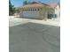 Home's garage featuring an automatic door, long driveway, and desert landscaping at 1611 Red Rock Dr, Pahrump, NV 89048