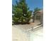View of the side yard featuring drought-resistant landscaping, a mature tree, and gated access at 1611 Red Rock Dr, Pahrump, NV 89048