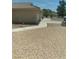 Side view of the yard and home; desert-friendly landscaped yard with walkway to the front at 1611 Red Rock Dr, Pahrump, NV 89048