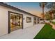 Backyard with covered patio, green lawn, mature palm trees, and lush landscaping at 1616 Shadow Rock Dr, Las Vegas, NV 89117