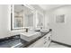 Modern bathroom featuring double sinks, illuminated mirrors, and sleek countertops at 1616 Shadow Rock Dr, Las Vegas, NV 89117