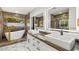 Elegant bathroom showcasing marble accents, illuminated mirrors, dual sinks, and a modern tub at 1616 Shadow Rock Dr, Las Vegas, NV 89117