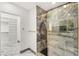 Elegant bathroom with a glass shower, marble tile, and an adjacent custom closet at 1616 Shadow Rock Dr, Las Vegas, NV 89117