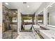 Luxurious bathroom featuring marble tile, dual sinks, garden tub, and glass shower enclosure at 1616 Shadow Rock Dr, Las Vegas, NV 89117