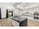 Kitchen with modern island, stainless appliances, stone countertop, and backyard views through large windows at 1616 Shadow Rock Dr, Las Vegas, NV 89117