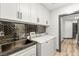 Stylish laundry room with modern cabinets, sink, and laundry machines at 1616 Shadow Rock Dr, Las Vegas, NV 89117