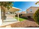Private backyard features covered patio, gravel beds, mature trees, and artificial turf at 1917 Badger Canyon Ave, North Las Vegas, NV 89031