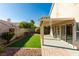 Backyard featuring artificial turf, mature trees, covered patio, and well-maintained landscaping at 1917 Badger Canyon Ave, North Las Vegas, NV 89031