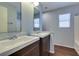 Modern bathroom with double vanity, wood cabinets, and large mirror and natural light at 1917 Badger Canyon Ave, North Las Vegas, NV 89031