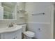 Bright bathroom with vanity, decorative mirror, floating shelves, and toilet at 1917 Badger Canyon Ave, North Las Vegas, NV 89031