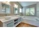 Bright bathroom features double sinks, modern fixtures, soaking tub, and wood-look floors at 1917 Badger Canyon Ave, North Las Vegas, NV 89031