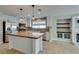 Updated kitchen with an island, stainless steel appliances, mosaic backsplash, and modern lighting at 1917 Badger Canyon Ave, North Las Vegas, NV 89031