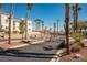 Well maintained community entrance with gate, landscaping, palm trees, and American flag at 1928 Las Palmas Ln # 228, Laughlin, NV 89029