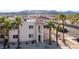 Charming condo with stucco siding, red tile roof, tropical palm trees, and desert landscaping at 1928 Las Palmas Ln # 228, Laughlin, NV 89029