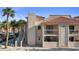 A condo featuring stucco siding, red tile roof, private balconies, and tropical palm trees at 1928 Las Palmas Ln # 228, Laughlin, NV 89029