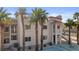 Condo exterior with stucco, red tile roof, tropical palm trees, and landscaping at 1928 Las Palmas Ln # 228, Laughlin, NV 89029
