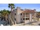 Condo featuring stucco siding, red tile roof, private balconies, and surrounded by palm trees at 1928 Las Palmas Ln # 228, Laughlin, NV 89029