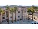 A condo featuring stucco siding, red tile roof, and tropical palm trees against mountain backdrop at 1928 Las Palmas Ln # 228, Laughlin, NV 89029
