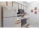 Bright kitchen with white appliances, including a refrigerator, oven, and microwave, providing essential amenities at 1928 Las Palmas Ln # 228, Laughlin, NV 89029